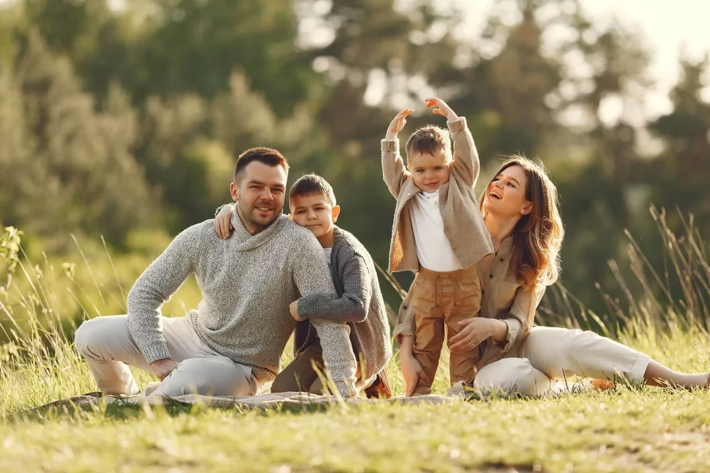 A family of four relaxing together outdoors, representing the families Osman Law supports through divorce, custody, and adoption matters in Stephenville, TX